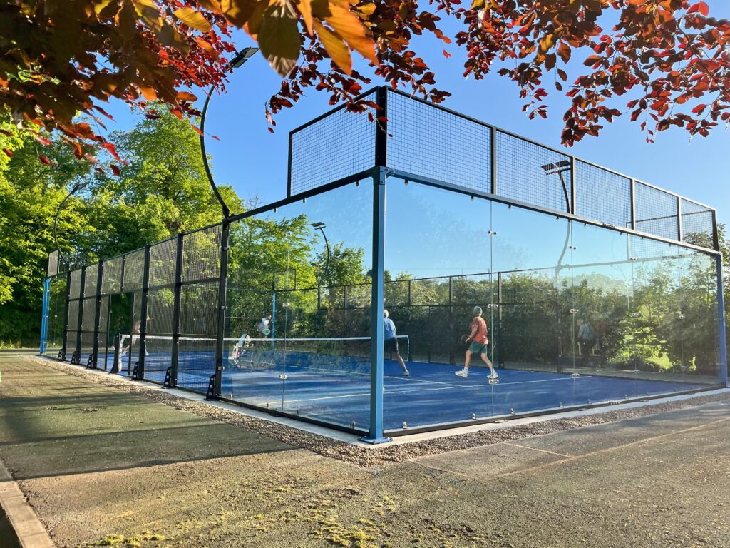 People playing on outdoor padel court on old tennis base