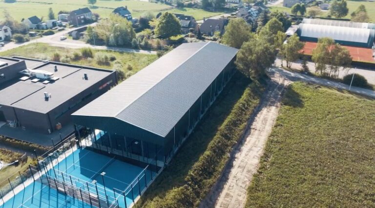 Padel court under enclosed canopy with outdoor courts alongside
