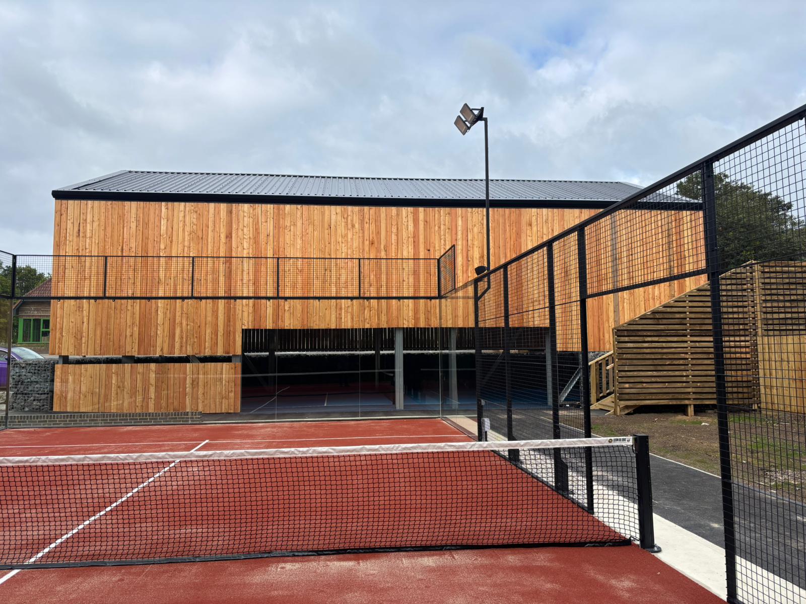 Padel court canopies can by fully enclosed or open with wooden or steel cladding